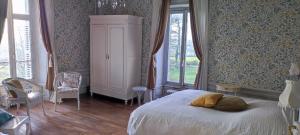 una camera da letto con un letto e una grande finestra di Le Manoir du Châtelier a Bressuire