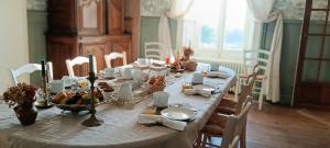a long table with food on it in a dining room at Le Manoir du Châtelier in Bressuire