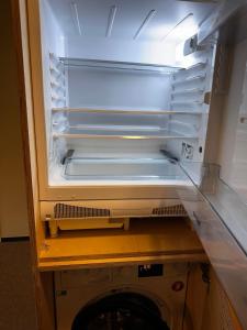 an empty refrigerator with its door open in a kitchen at The 4th Floor Vista in front of Kokhta in Bakuriani