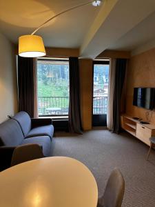 a living room with a couch and a table at The 4th Floor Vista in front of Kokhta in Bakuriani