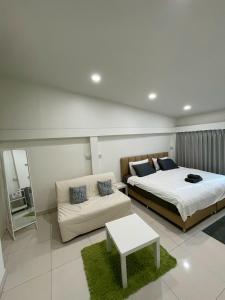 a bedroom with two beds and a couch in it at Namasstay Silom in Chinatown