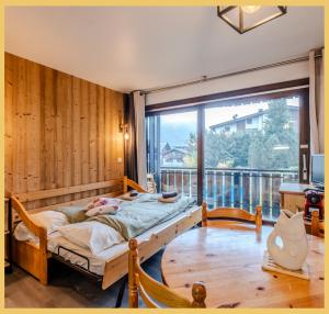 a bedroom with a bed and a large window at Le Paradisio I Studio I Morzine in Morzine