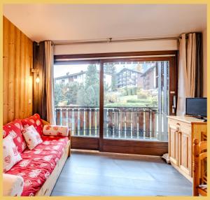 a living room with a couch and a large window at Le Paradisio I Studio I Morzine in Morzine