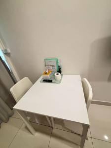 a white table with two chairs and a tray of food at Namasstay Silom in Chinatown