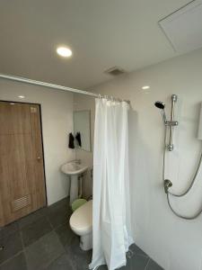 a bathroom with a toilet and a shower curtain at Namasstay Silom in Chinatown