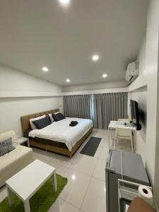 a bedroom with a bed and a tv and a couch at Namasstay Silom in Chinatown