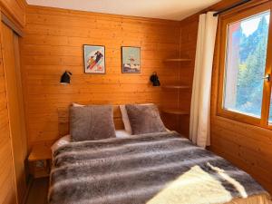 une chambre avec un lit avec une couverture et une fenêtre dans l'établissement Méribel Mottaret - Duplex - Plein sud - Pied des pistes, à Les Allues