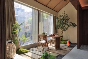a room with a table and chairs and a large window at Return Courtyard Hotel in Chengdu