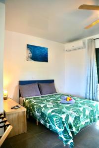 TeahupooにあるTeahupo'o Lodge Tahiti - Studio Evasion - climatisé - entre randonnées et activités nautiquesのベッドルーム1室(緑色のベッドカバー付)