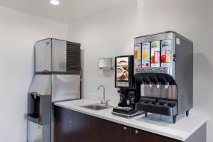 a kitchen with a sink and a coffee machine at Avion Inn Near LGA Airport, an Ascend Collection Hotel in Queens