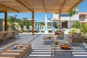 a patio with tables and chairs and a pool at Lanik Luxury Pool Villa in Afantou