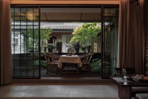 a dining room with a table and glass doors at Return Courtyard Hotel in Chengdu
