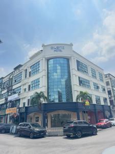 a building with cars parked in front of it at Blenz Hotel in Serdang