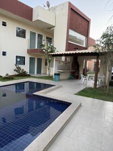 サンタ・クルース・カブラーリアにあるAp em Cor vermelha - perto do mar da cultura Pataxóの家の前にプールがある家