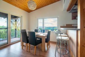 a dining room with a table and chairs and windows at Ferienwohnung Agnes in Rappersweier