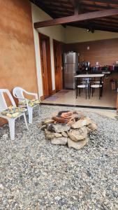 a group of chairs and a table and a kitchen at Chalés Sitío dos Ventos in Lavras Novas