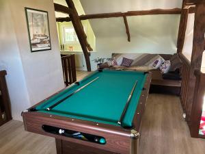 a pool table in a living room with a couch at La Gentilhommière in Rogerville