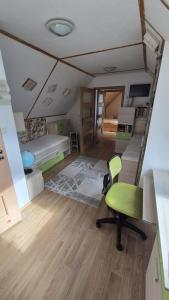 Una habitación con una cama y una silla verde dentro. en Romantic House in Botanic Garden, en Banská Štiavnica