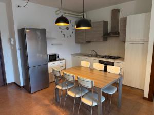 a kitchen with a wooden table and chairs and a refrigerator at Appartamento La Triade in Bonavicina