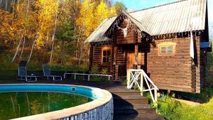 une cabane en rondins avec une piscine en face de celle-ci dans l'établissement El Rancho De Stayki, à Stayki