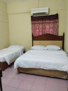 a bedroom with two beds and a air conditioner on the wall at Homestay Haji Hamid in Pantai Cenang +37 photos