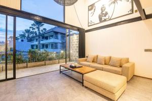 a living room with a couch and a table at Expansive Loft 200m From Canggu Beach Haven in Canggu
