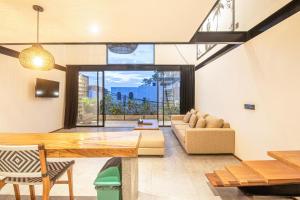 a living room with a table and a couch at Expansive Loft 200m From Canggu Beach Haven in Canggu