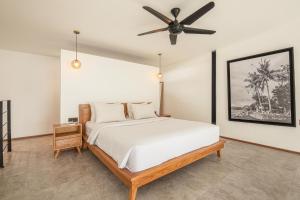 a bedroom with a bed and a ceiling fan at Expansive Loft 200m From Canggu Beach Haven in Canggu