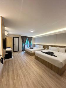 邦咯Alva Boutique Chalet Pangkor的有两张床和一台电视的酒店房间