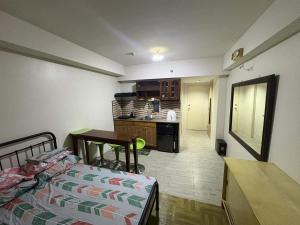 a living room with a bed and a kitchen at AMAIA Condo Mandaue in Mandaue City