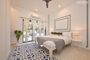 a bedroom with a large bed with a blue and white rug at EKOSTAY Luxe - Ivory Coast Villa in Alibaug