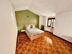 a bedroom with a bed and a green wall at Maison de vacances à Cunéo in Valloriate