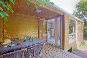 une terrasse en bois avec une table et des chaises dessus dans l'établissement CityKamp Strasbourg, à Strasbourg