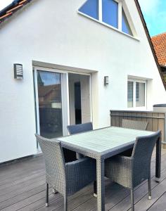 a patio with a table and chairs on a deck at Schneider Appartements Steinhude in Niederdorla