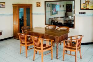 a dining room with a wooden table and chairs at My Cafe Hotel near UGM Yogyakarta Mitra RedDoorz in Kejayan