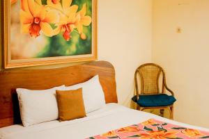 a bedroom with a bed with a painting on the wall at My Cafe Hotel near UGM Yogyakarta Mitra RedDoorz in Kejayan