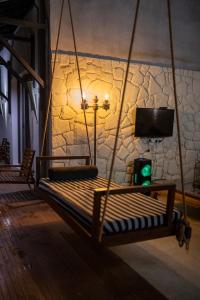 a swinging bed in a room with a tv at Ella Nine Peaks in Ella