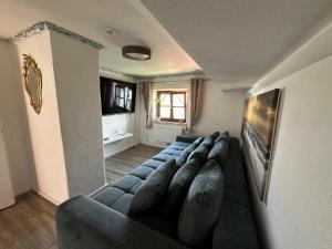 a living room with a blue couch and a television at Heimat Apartment in Grafing