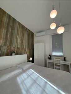 a bedroom with a large white bed with two lights at Da Marianna in Castelnuovo Rangone