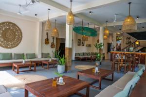 a living room with tables and couches and chairs at Drifter - Rooms & Food in Midigama