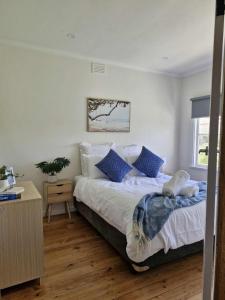 ein Schlafzimmer mit einem großen Bett mit blauen Kissen in der Unterkunft Seabreaze cottage sleeps 6 in Portland