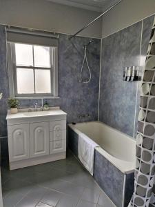 ein Badezimmer mit Badewanne und Waschbecken in der Unterkunft Seabreaze cottage sleeps 6 in Portland
