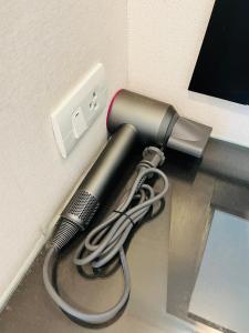 a blow dryer plugged into a wall outlet at Lulu Hotel in Ban Phlu Yai