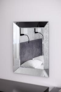 a mirror reflecting a bed with two pillows at Hotel Felicia in Rīga