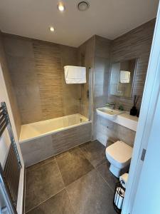 een badkamer met een bad, een toilet en een wastafel bij Stylish 1BR with Comfy Vibes in Beckenham