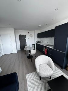 een woonkamer met een stoel en een tafel bij Stylish 1BR with Comfy Vibes in Beckenham