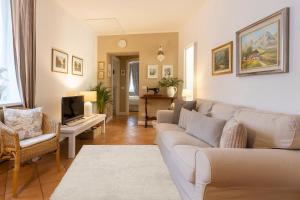 a living room with a couch and a tv at TRENTINO LODGE Via San Vito in Strigno
