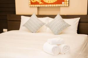 a bed with two towels on top of it at Lulu Hotel in Ban Phlu Yai +1 photo