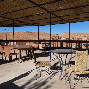 un patio con mesas y sillas y vistas al desierto en La Belle Vue Guest House, en Aït Ben Haddou