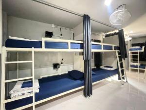 Zimmer mit 3 Etagenbetten mit blauer Bettwäsche in der Unterkunft Babyshark Hostel - Loh Dalum Bay in Ko Phi Phi